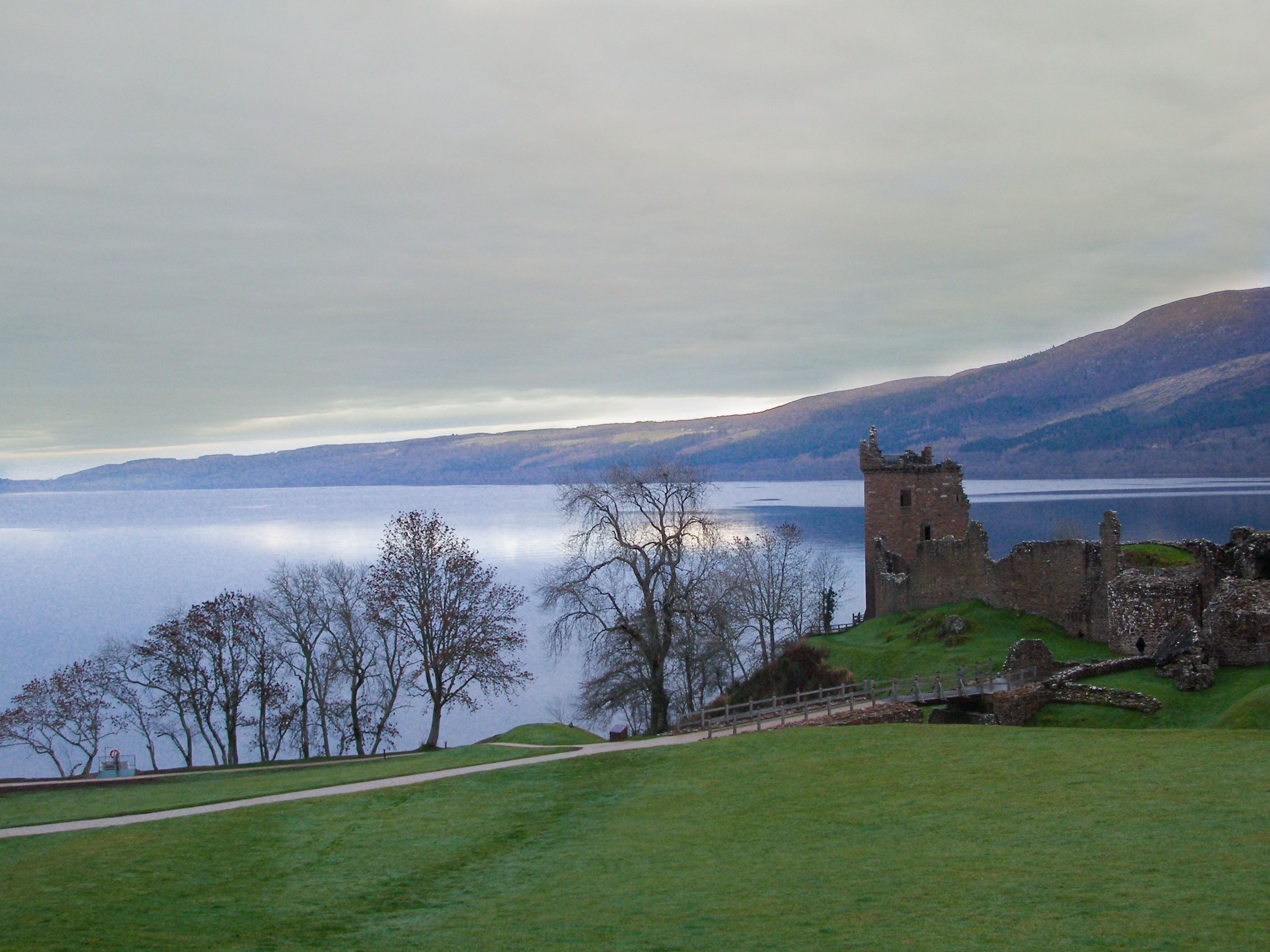  Urquhart Castle overlooking Loch Ness, with grass and leaveless trees in the forefront