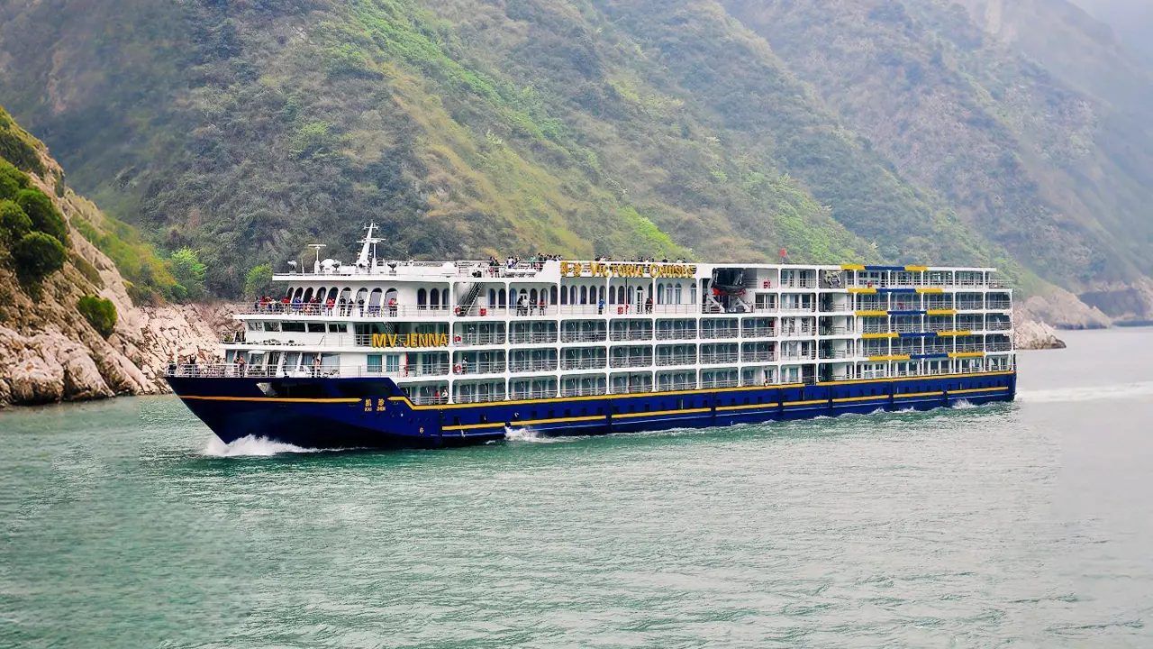 Exterior view of the Victoria Jenna cruise ship sailing through scenic river gorges in China, showcasing its multiple decks and elegant design