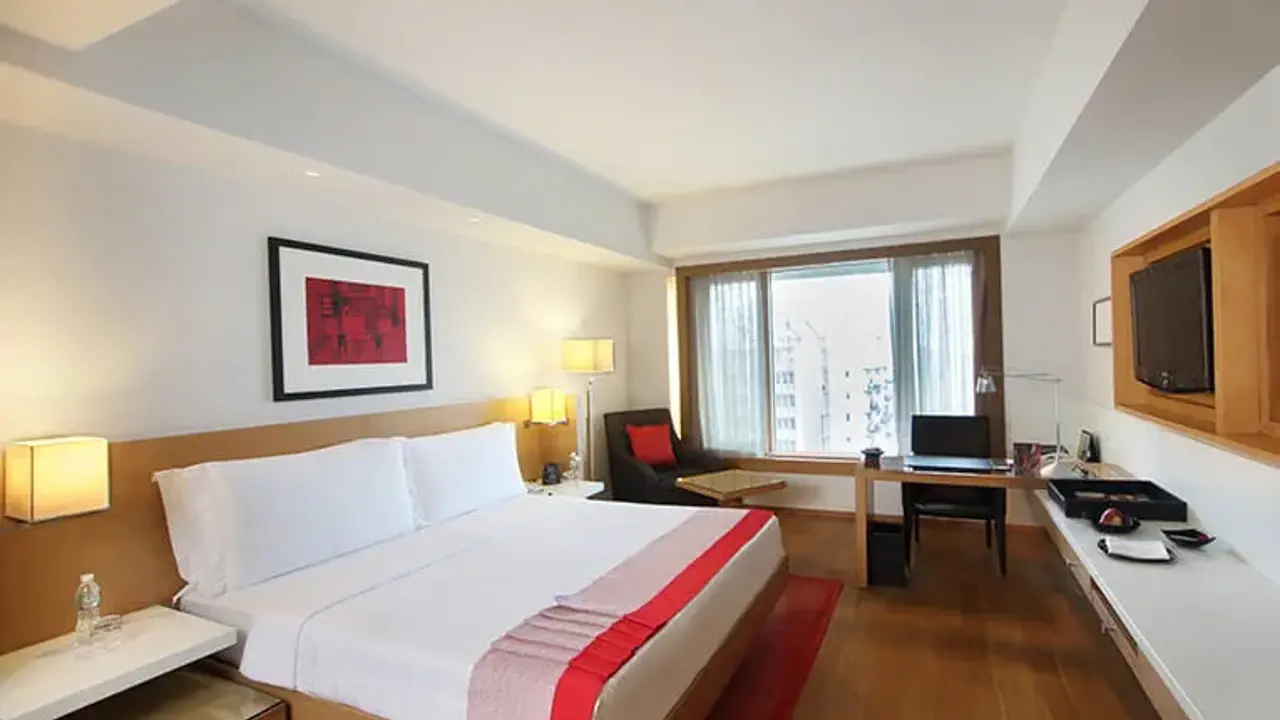 A city view room at Trident Nariman Point, Mumbai, featuring a double bed, wooden floors, and cosy warm lighting