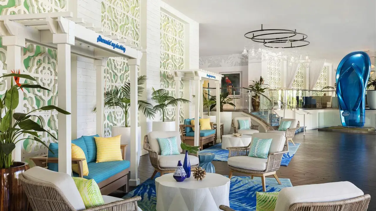 Bright and colourful lobby at the Riviera Resort & Spa, Palm Springs, featuring a vibrant blue and green colour palette, modern white seating with coordinating cushions, and a stylish, contemporary atmosphere