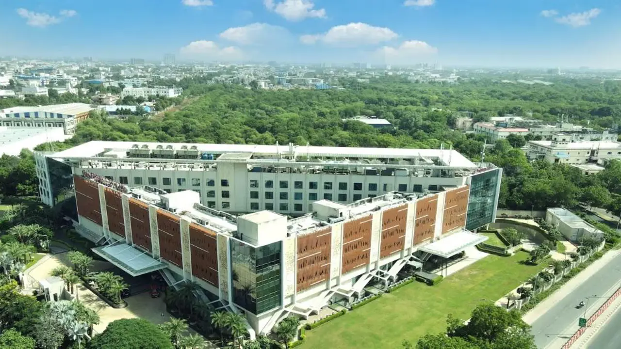 A daytime aerial view of the InterContinental Jaipur surrounded by trees and city buildings