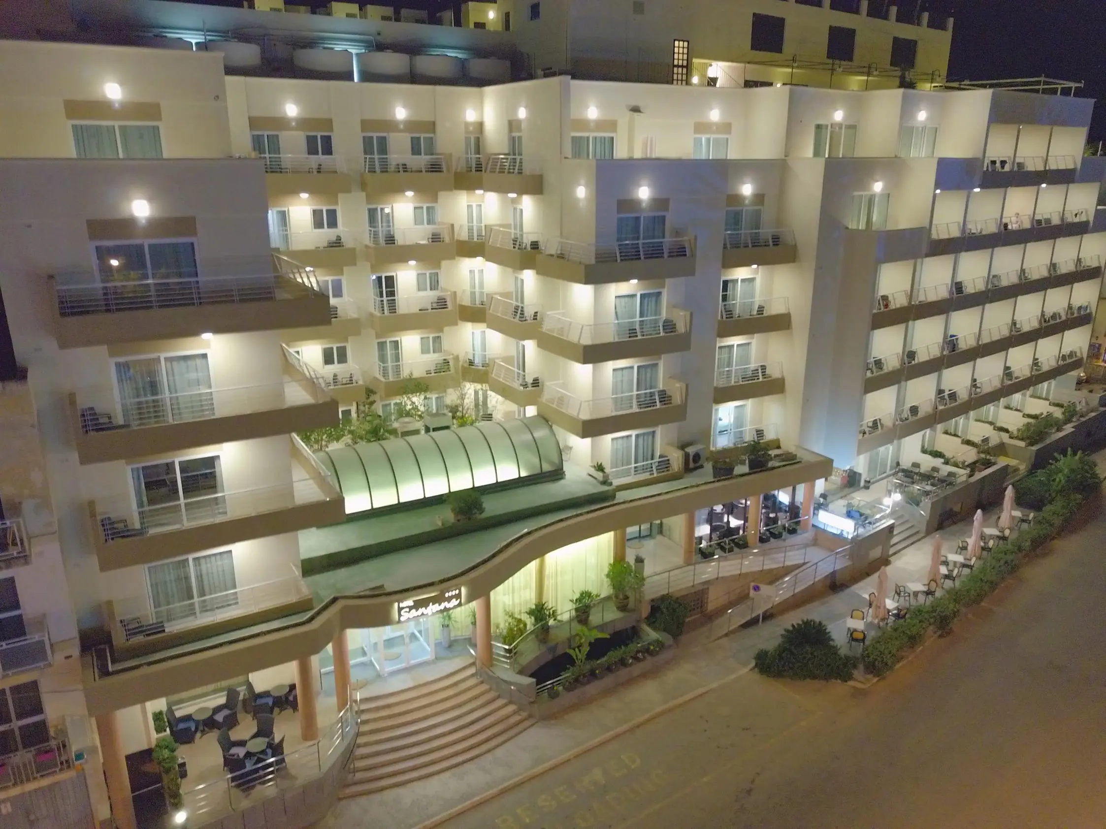 Exterior of Hotel Santana in St Paul’s Bay, Malta at night, with the building brightly lit and balconies visible