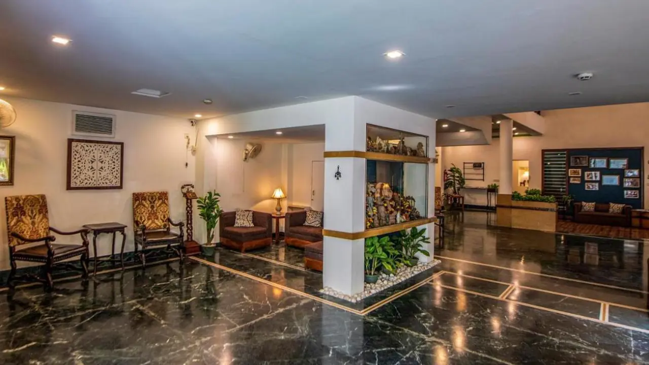 The reception at Ranthambore Regency hotel with dark marble floors, warm and neutral décor and dark wood furnishings