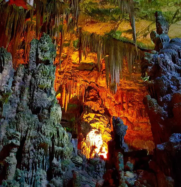 Interior view of Castellana Grotto cave with illuminated stalactites and stalagmite