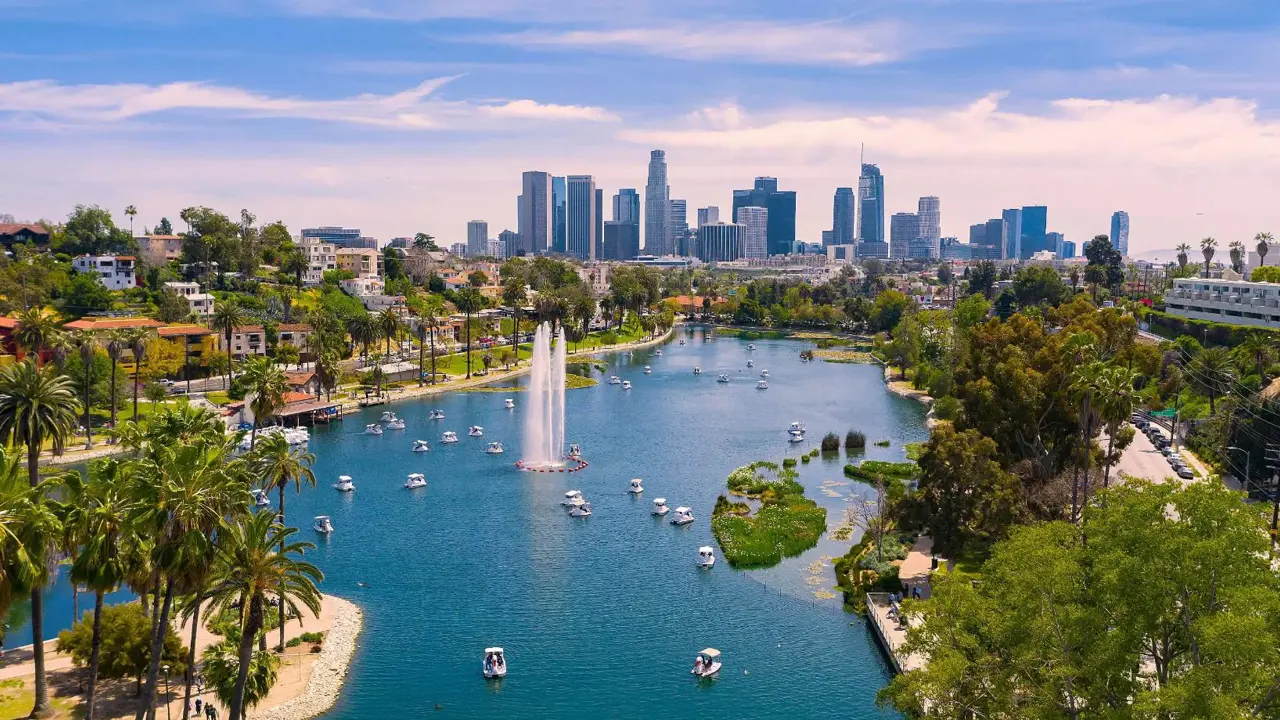 View of Los Angeles with a lake in the foreground, boats on the water, and the city skyline in the background