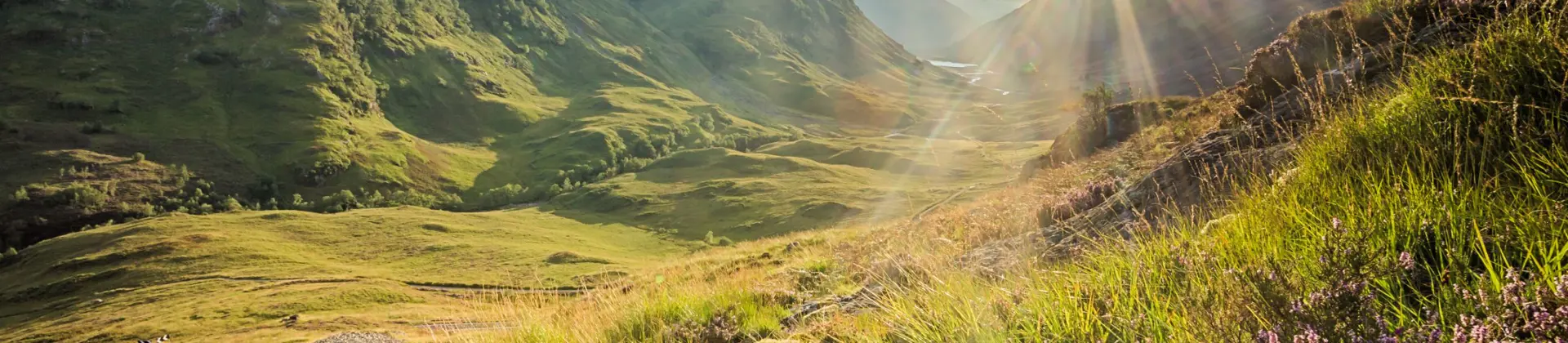 View of the Scottish Highlands with sunshine coming through behind them