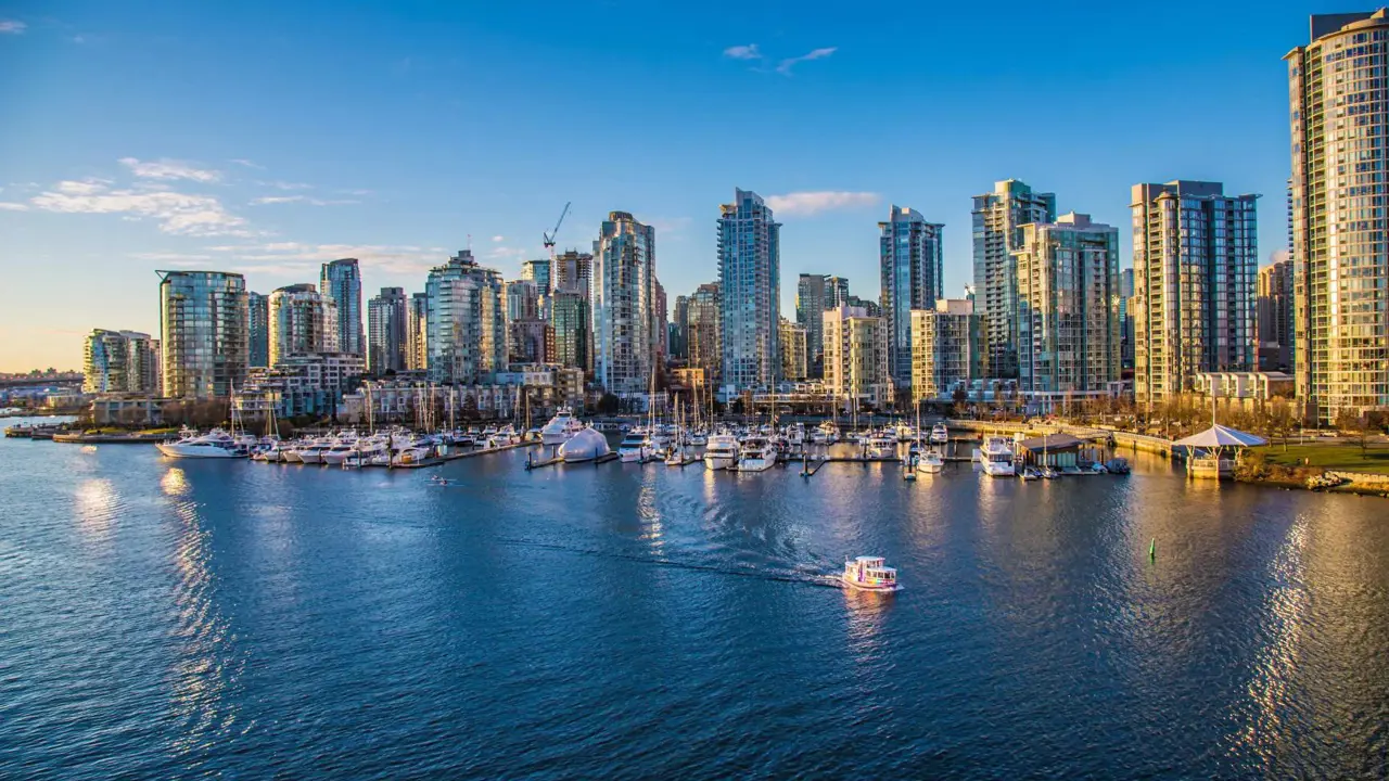 Aerial view of Vancouver Harbour, showing modern high-rise buildings along the waterfront and boats in the harbour