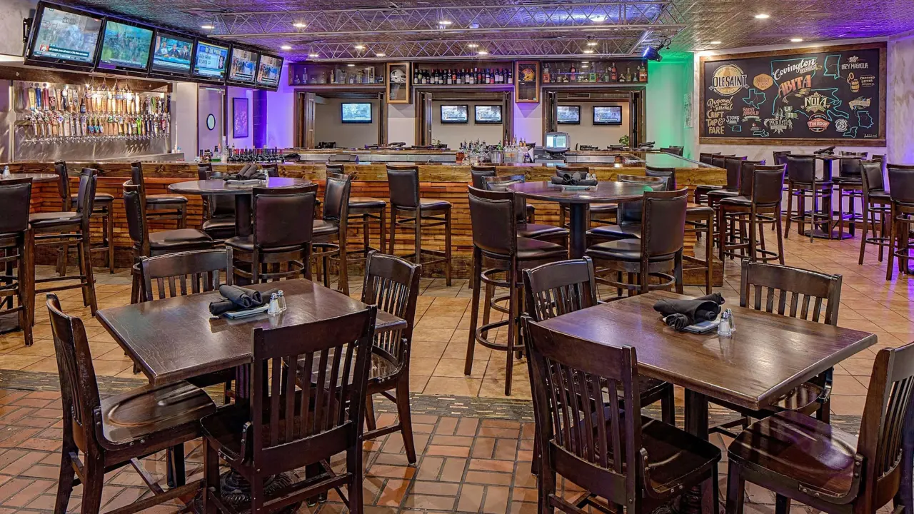 Casual dining area at Wyndham New Orleans French Quarter with wooden tables and chairs, warm lighting, and a relaxed atmosphere
