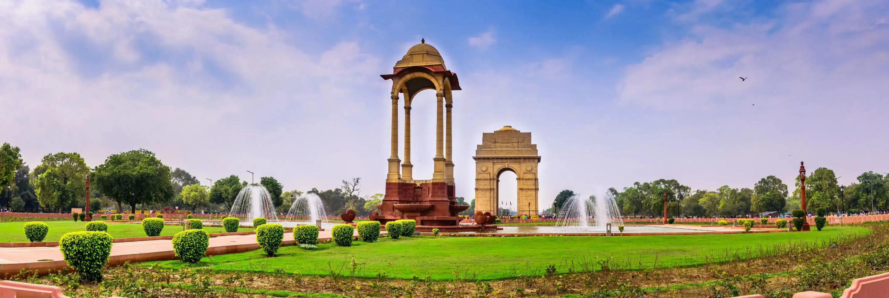 A view of India Gate and surrounding fountains and gardens in Delhi, India