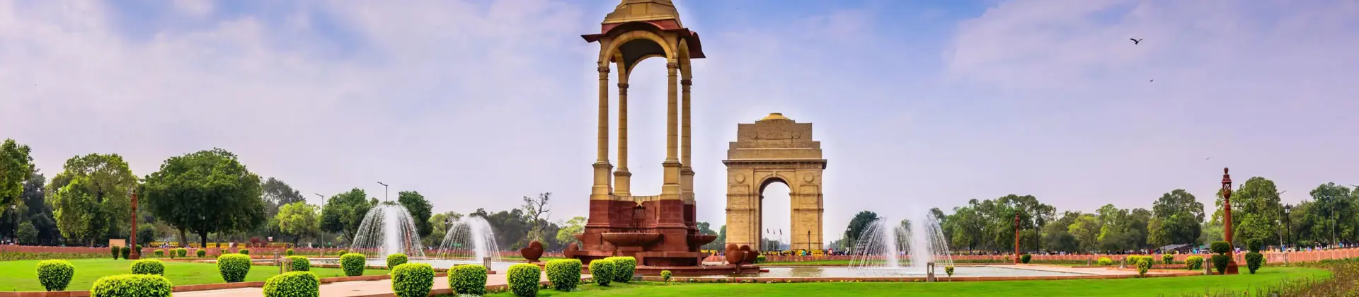A view of India Gate and surrounding fountains and gardens in Delhi, India