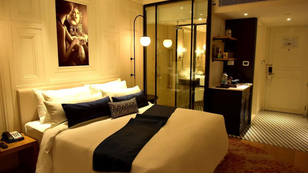 An elegant bedroom at Radisson Hotel Jass in Shimla with a plush double bed, neutral décor and warm lighting