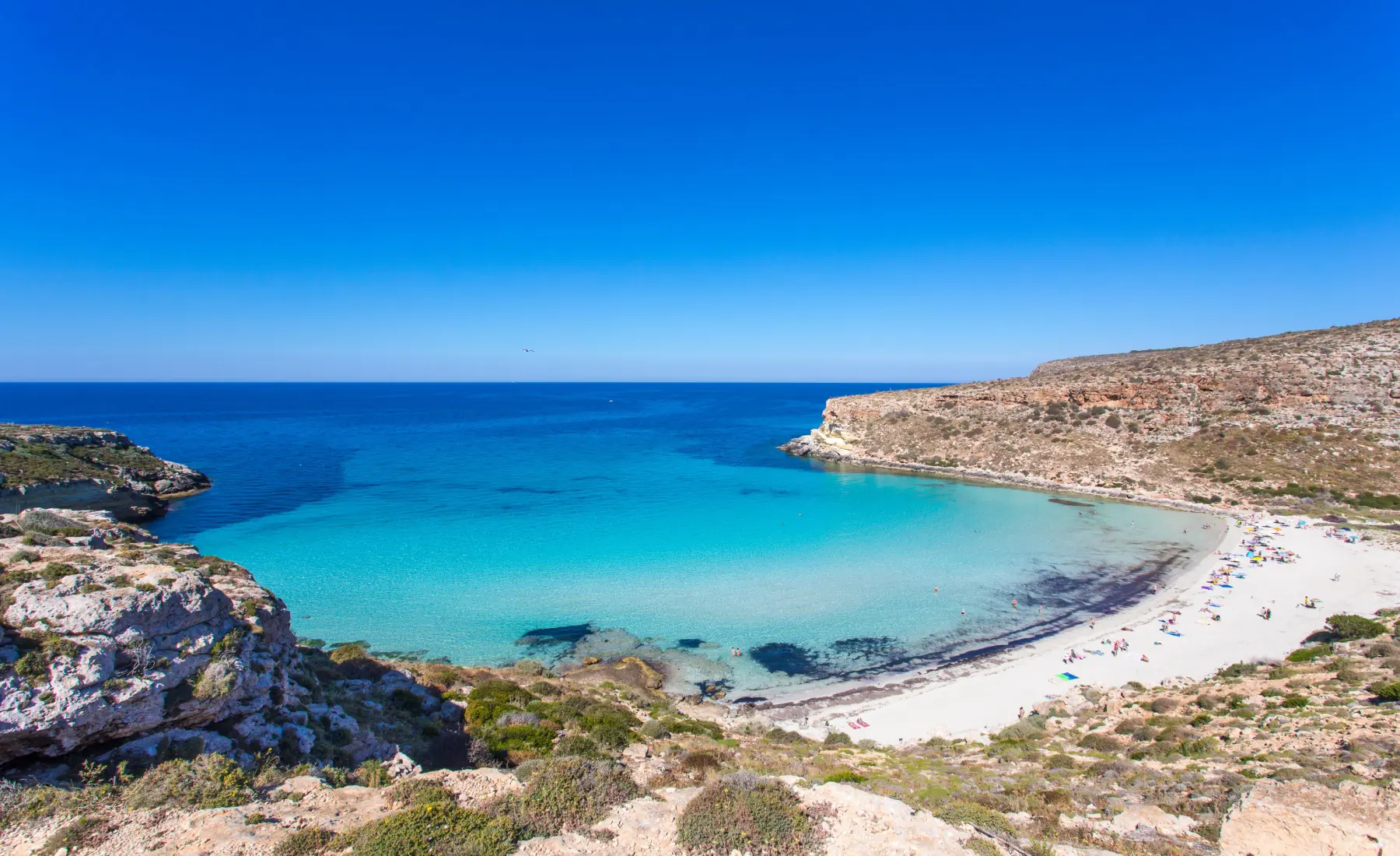 Spiaggia Libera Oncino beach, showing the bright blue sea and white sand