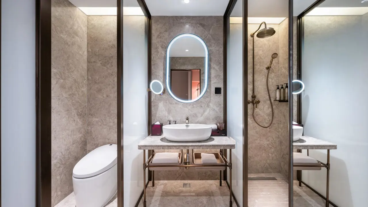 Modern bathroom with illuminated mirror, glass shower and marble surfaces at the Mercure Beijing Downtown Hotel, Beijing in China