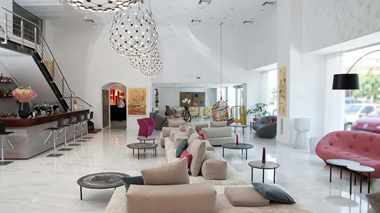 Bright, stylish lounge at the Athenaeum Grand Hotel featuring modern seating, bar area, and artistic lighting
