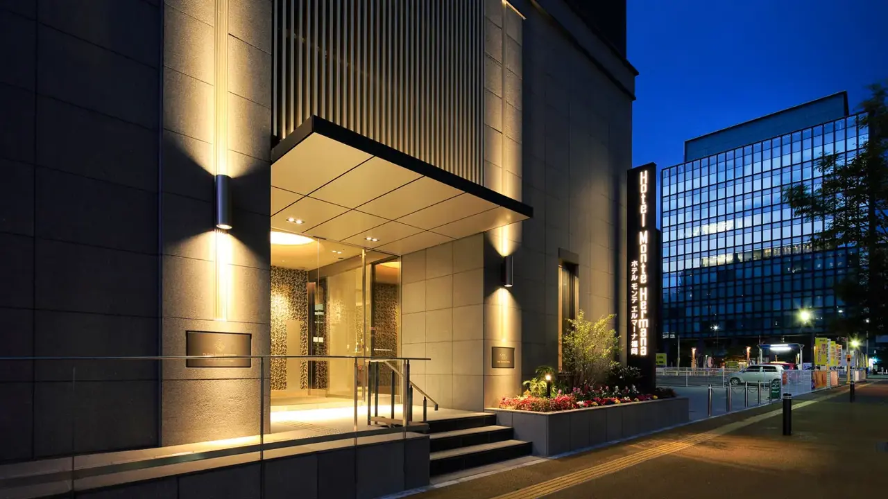 Exterior of Hotel Monte Hermana in Fukuoka, a modern high-rise building with a sleek façade and large windows, set in an urban cityscape