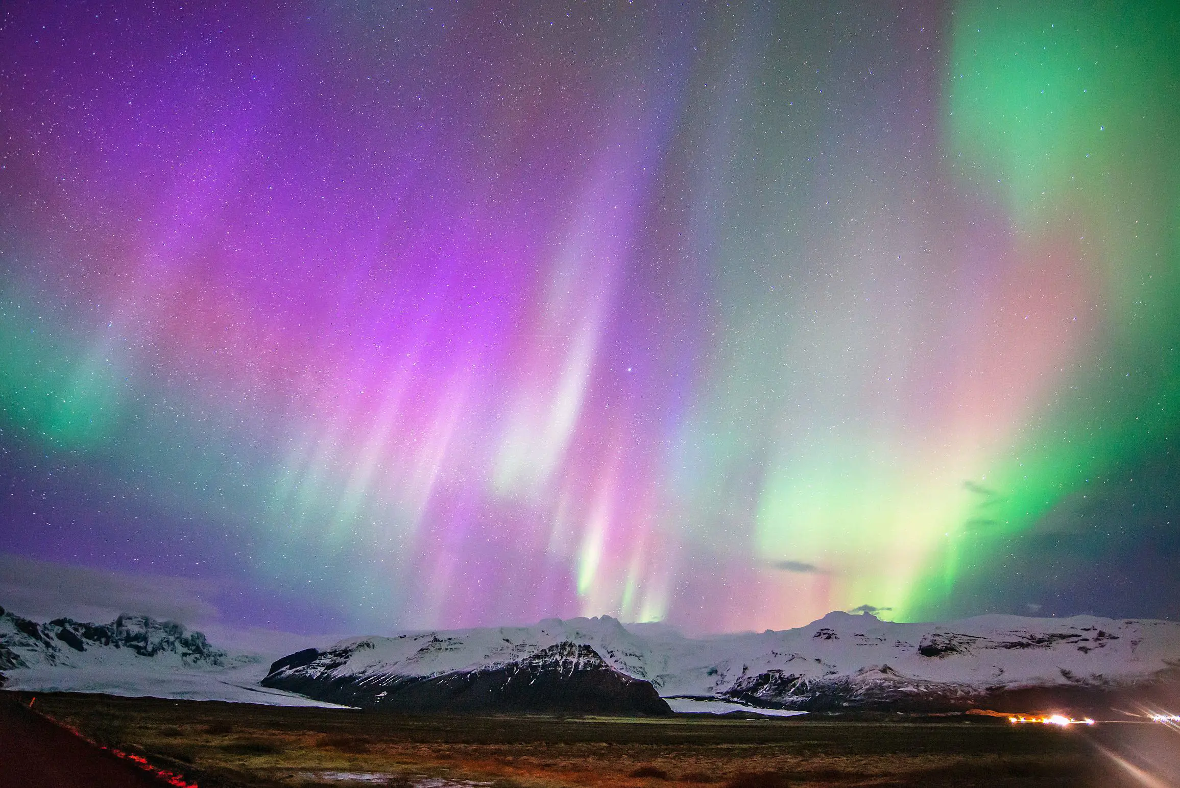Purple Northern Lights with hints of green, and snowy land below