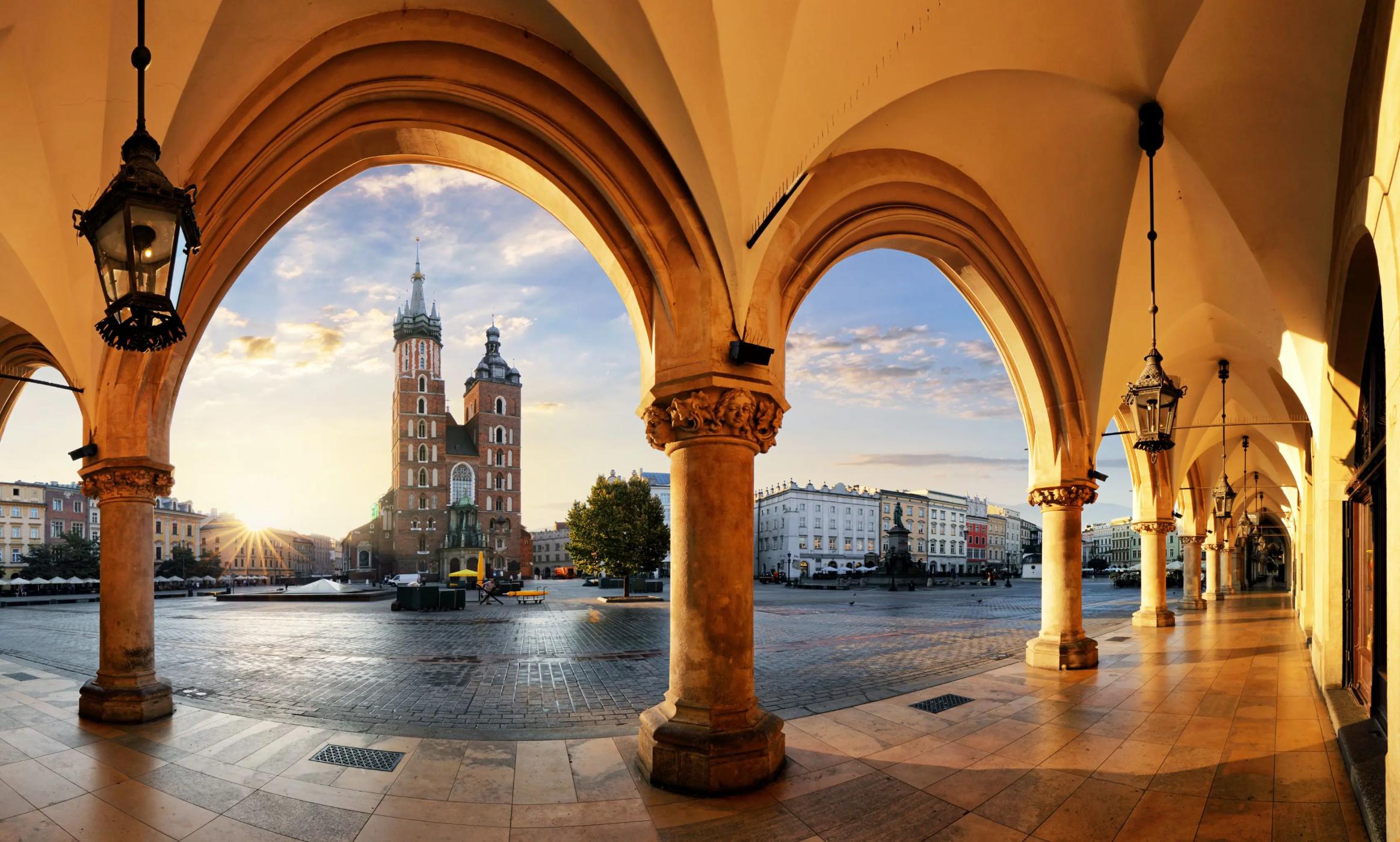 View of St. Mary's Basilica from the arches of the Cloth Hall in Kraków’s main square at sunrise