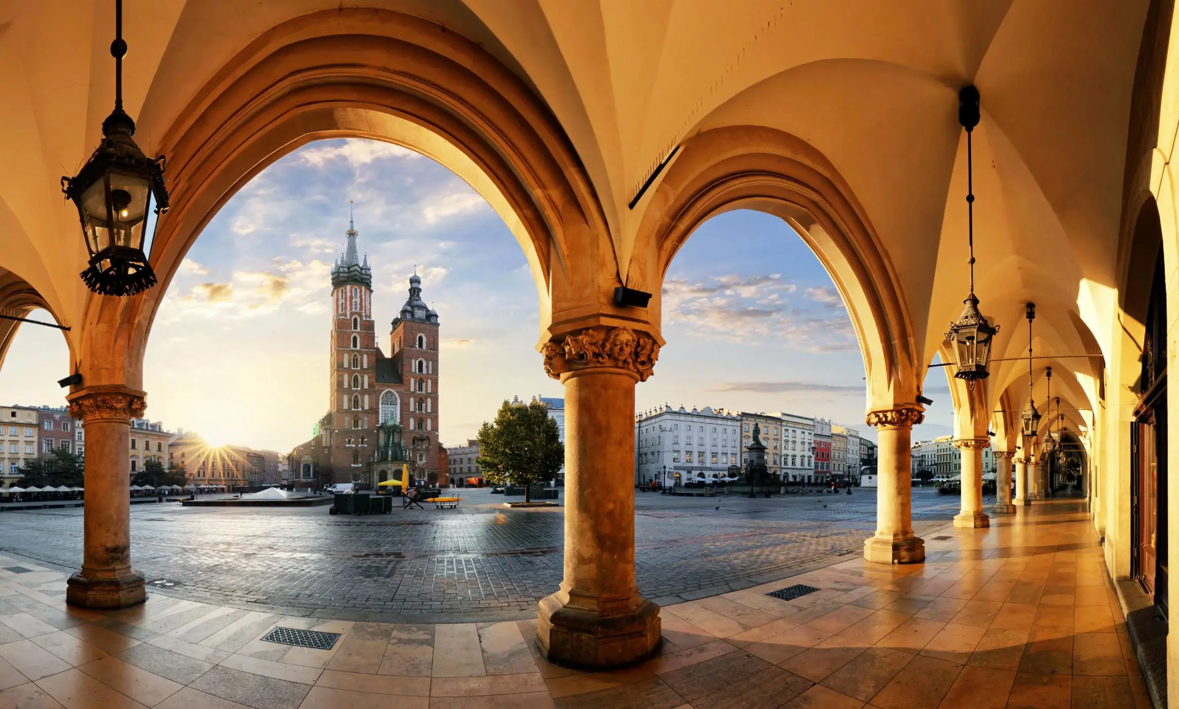 View of St. Mary's Basilica from the arches of the Cloth Hall in Kraków’s main square at sunrise