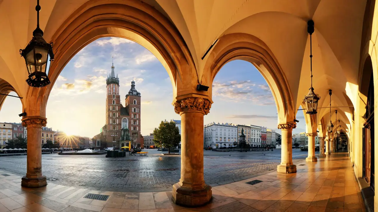 View of St. Mary's Basilica from the arches of the Cloth Hall in Kraków’s main square at sunrise
