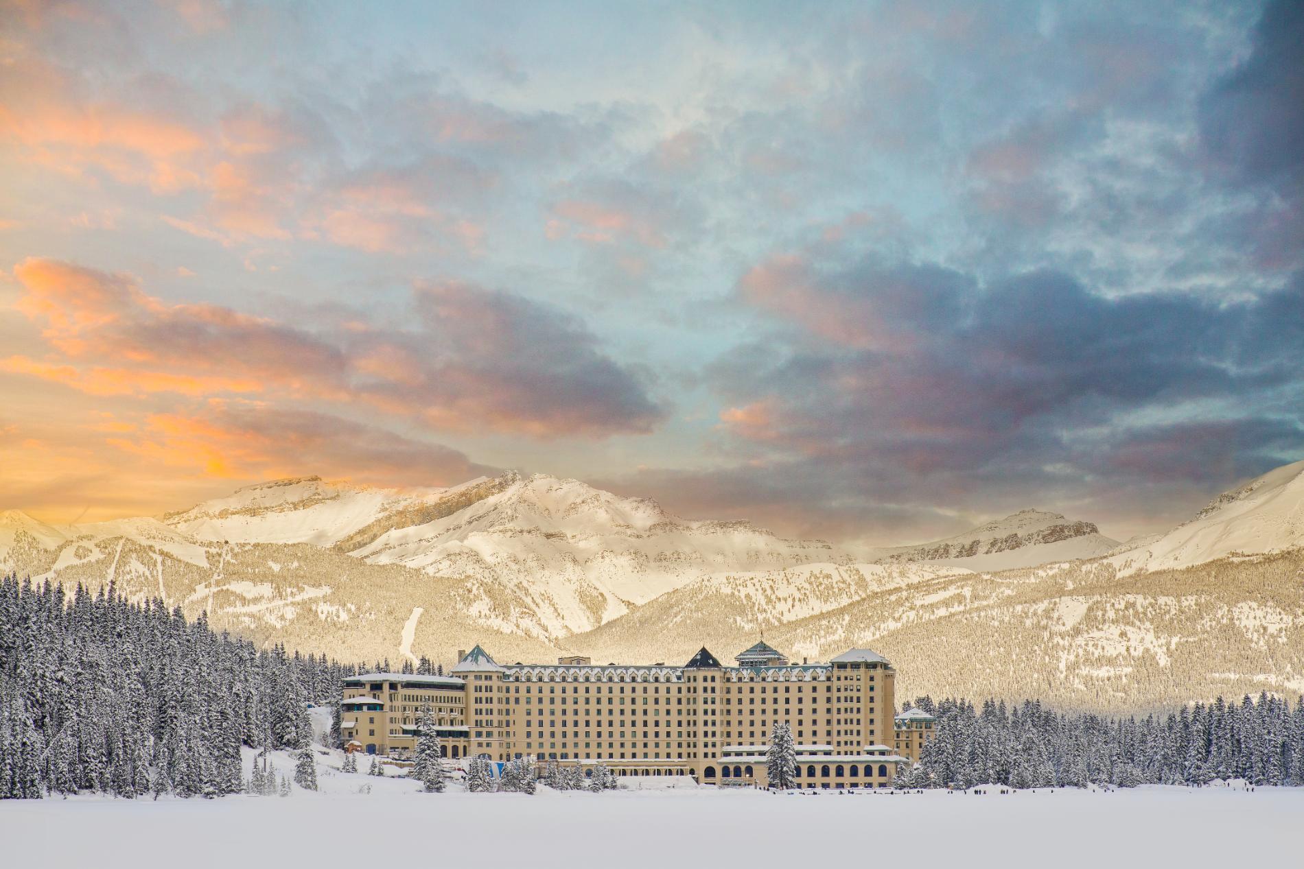 Fairmont Chateau, Lake Louise surrounded by snowy mountains at sunset