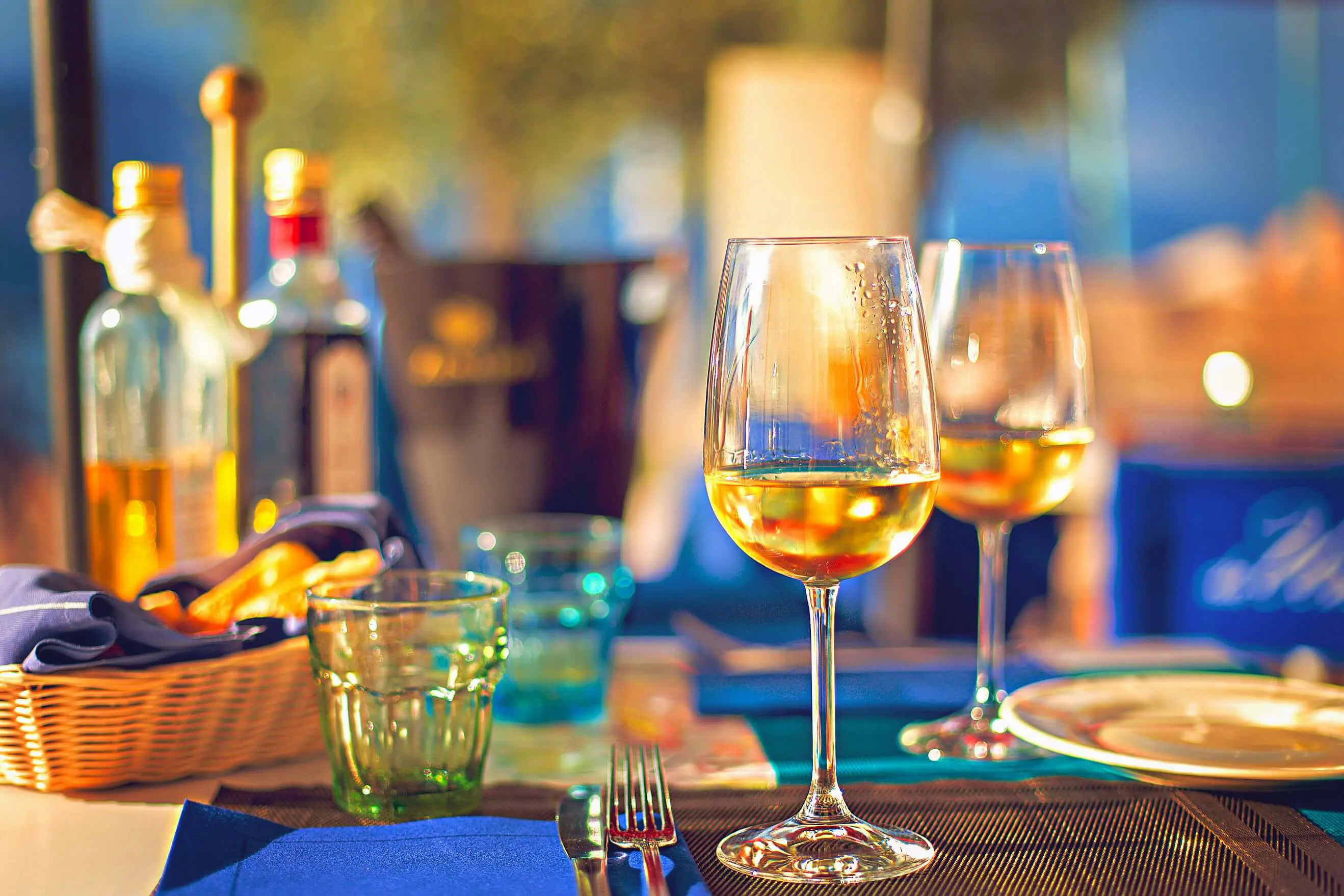 Laid dinner table with glasses of white wine