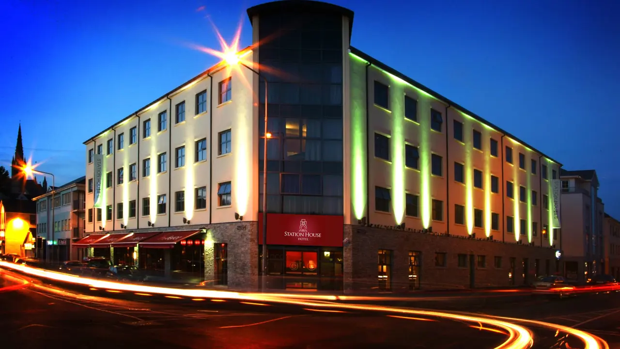 Exterior view of the Station House Hotel, Letterkenny at dusk, with illuminated façade and light trails from passing traffic