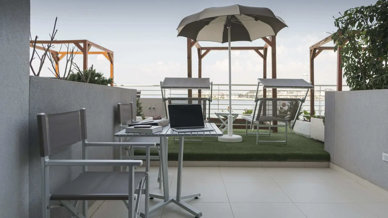 A private terrace at Hotel Split, Podstrana, with sun loungers, a parasol and sea views