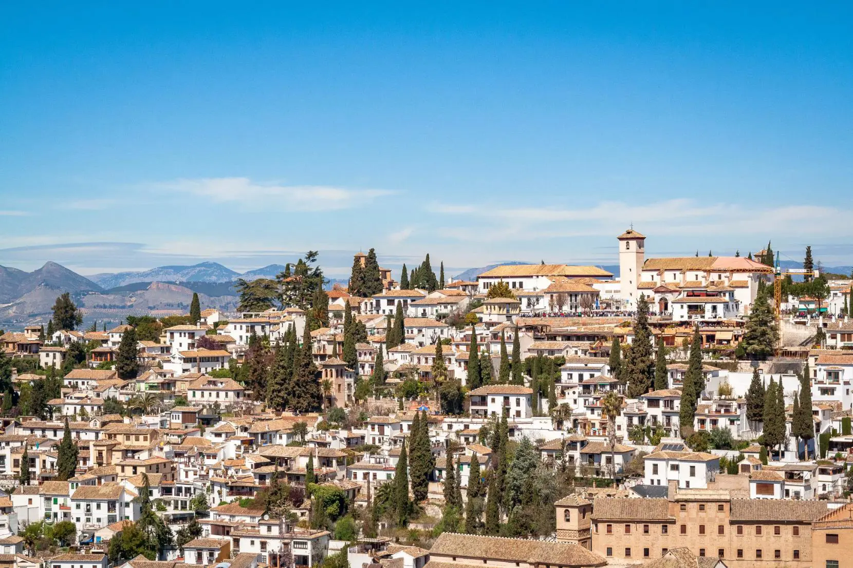 Traditional whitewashed houses on a hillside in a sunlit Andalucían village