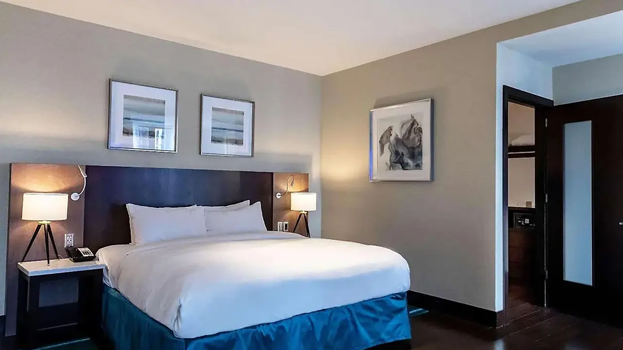 A bedroom at Radisson Blu Aqua Hotel, Chicago, featuring a king-size bed with crisp white linens, modern furnishings and elegant contemporary décor