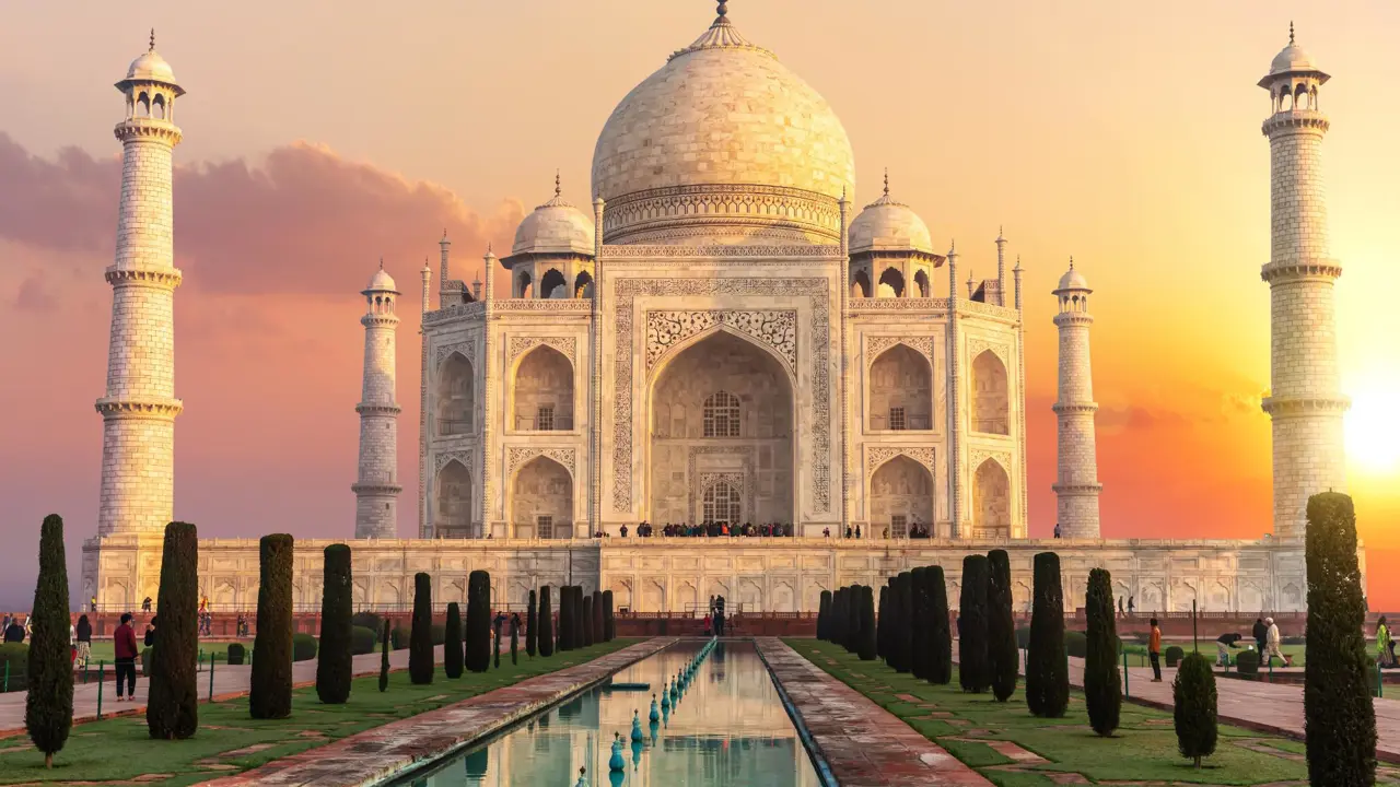 The Taj Mahal in Agra glowing in the warm hues of sunset, its white marble reflecting the golden light, with the surrounding minarets and the long reflecting pool in front adding to its majestic symmetry