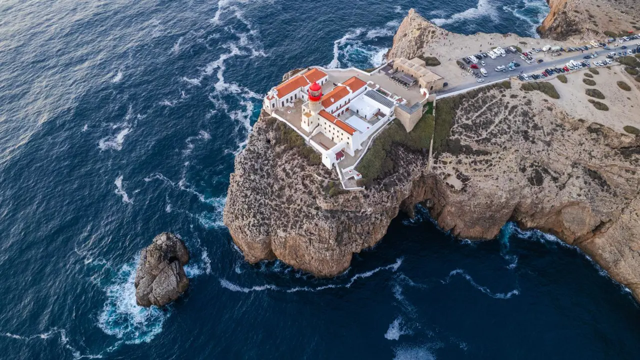 erial view of Cape St. Vincent on the Algarve, showing the lighthouse and courtyard on the cliff top surrounded by the sea