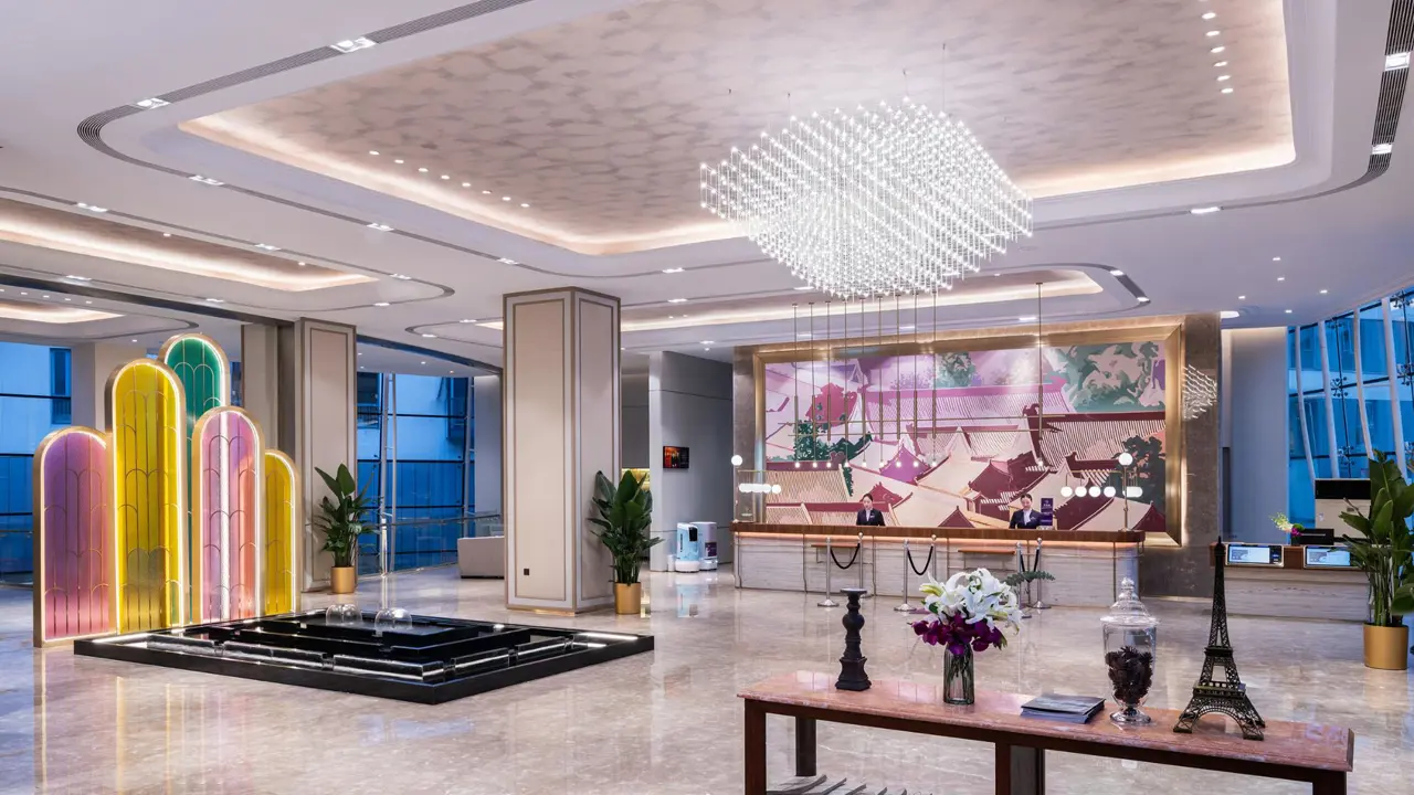 Elegant lobby with marble flooring, bronze accents and geometric ceiling lighting at the Mercure Beijing Downtown Hotel in Beijing, China