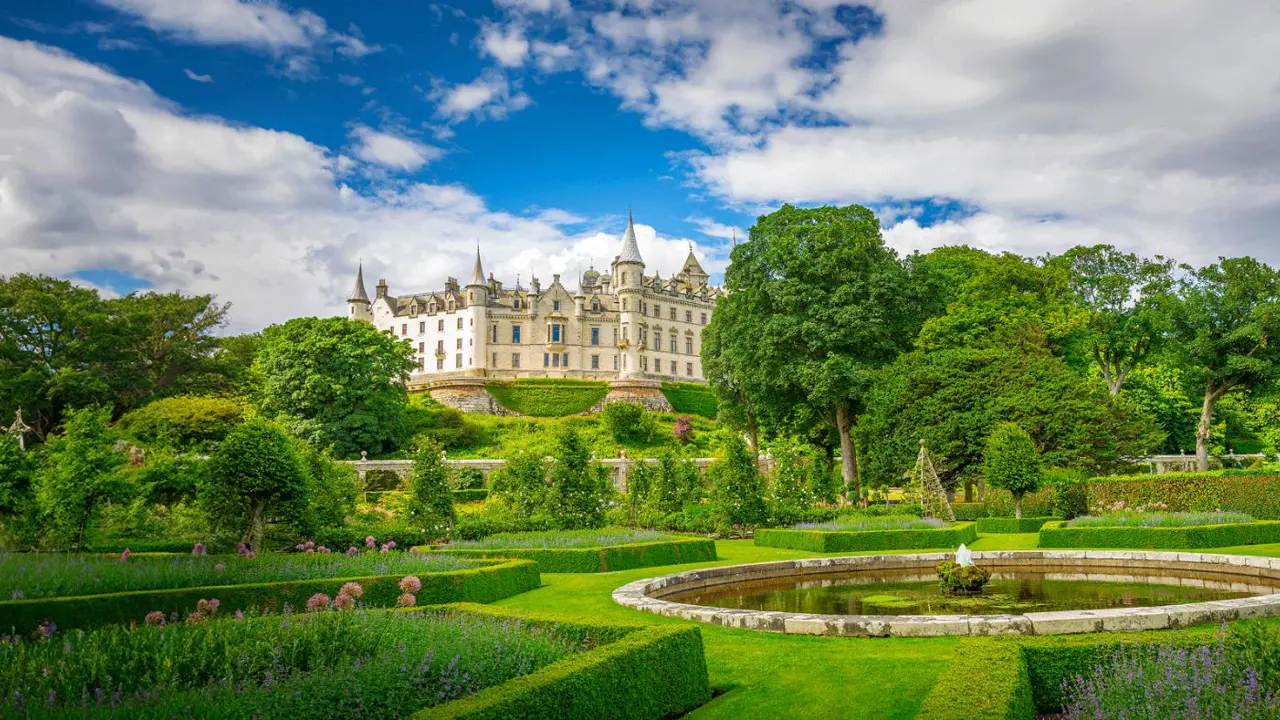 A view of historic Dunrobin Castle in Scotland, with its tall spires and turrets
