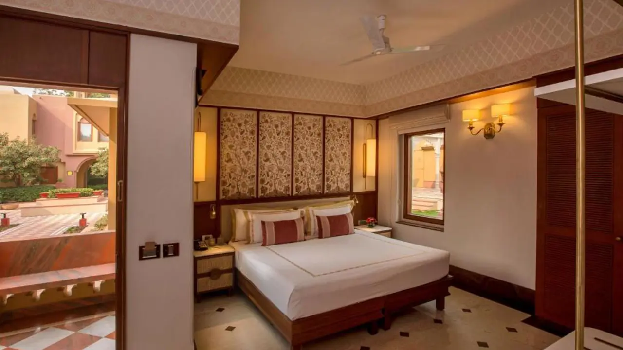 A cosy double room at Heritage Village Resort and Spa in Gurugram, featuring traditional décor, wooden furniture and soft lighting
