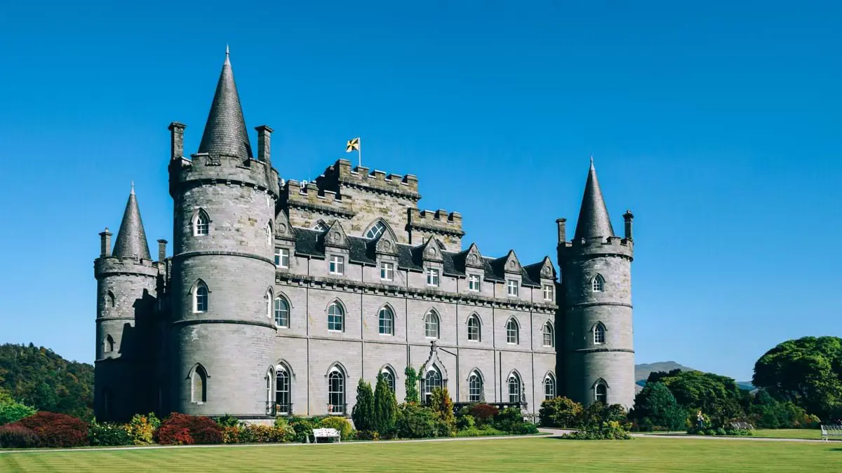 Shot of Inveraray Castle on a sunny day, with a blue sky and green grass infront 