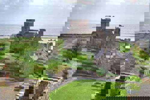 A peek at Dover castle including the St Mary of Castro church and the sea.