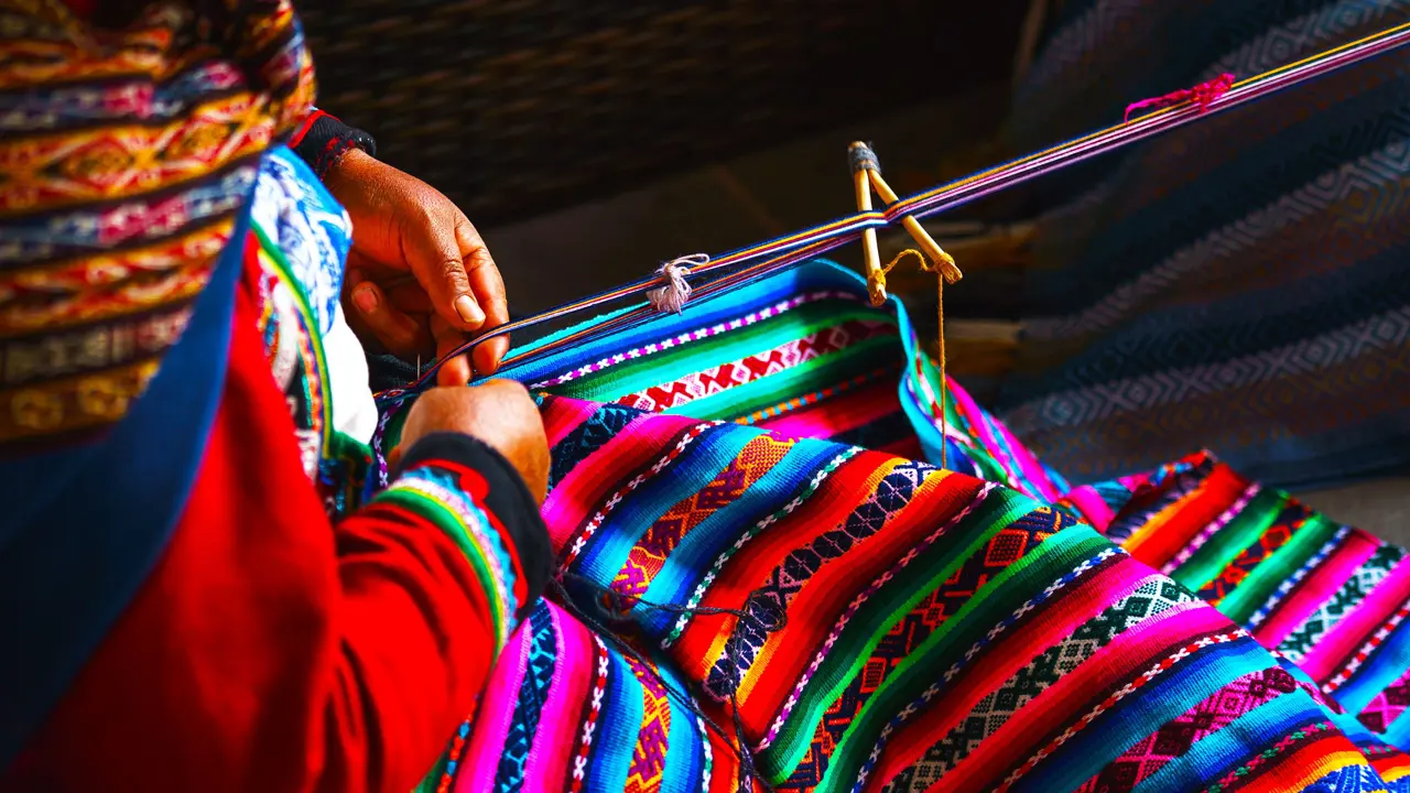 A Peruvian woman making a traditional wool carpet