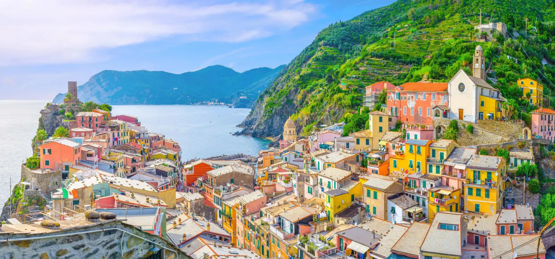 Scenic view of Vernazza, a colourful coastal village in Cinque Terre, with blue sea and a mountains in the distance