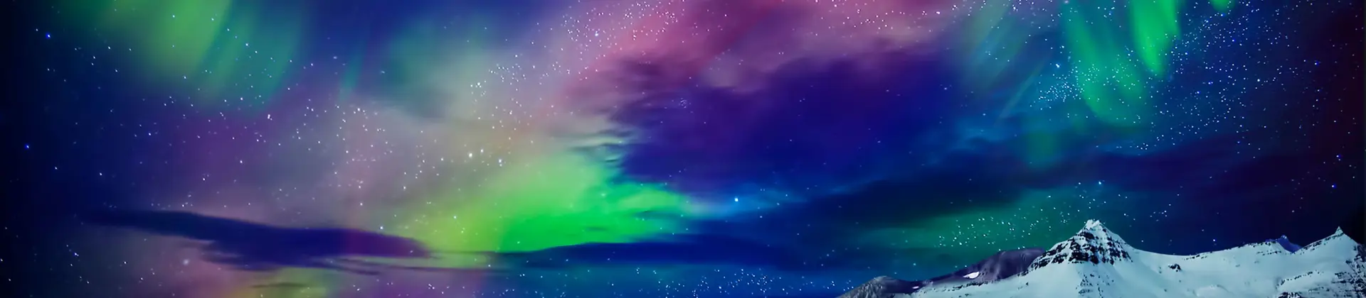 Starry sky with green, purple and blue Northern Lights. Below, a lake and a snowy mountain