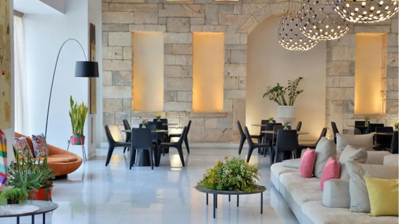 Elegant hotel lobby with marble floors, plush seating, and warm lighting at the Athenaeum Grand Hotel, Athens