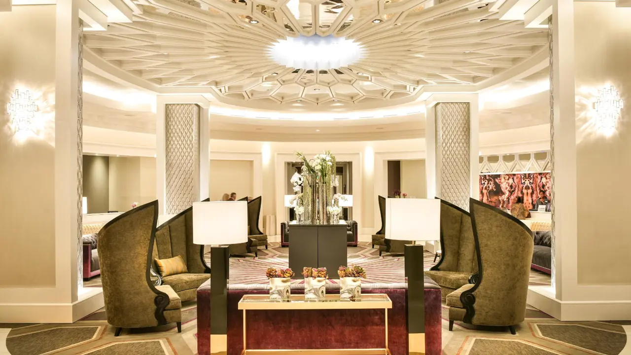The ornate lobby at The Guest House at Graceland, featuring high-backed chairs, modern lighting, and a stunning patterned ceiling